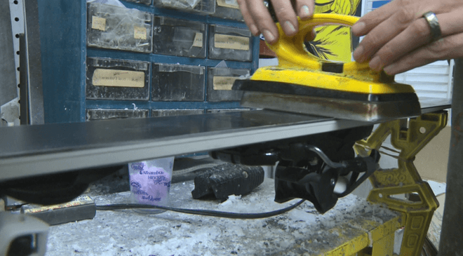 Hot wax being ironed onto a snowboard base